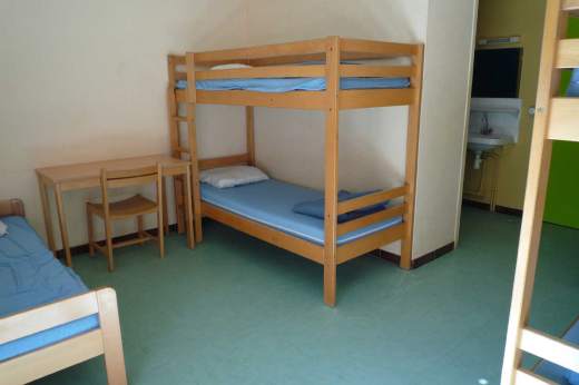 Chambre collective de 5 places avec 2 lits superposés et 1 lit simple située dans l'hébergement Lou Sanglier